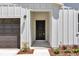 A black front door under a white portico adds a touch of modern elegance to the home's facade at 7007 Sw 131St Ave, Ocala, FL 34481