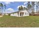 A modern home exterior with a well-maintained lawn and lush green trees surrounding the property at 7117 Sw 131St Ave, Ocala, FL 34481
