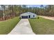 A modern one-story home with a gray garage door and well-maintained lawn at 7117 Sw 131St Ave, Ocala, FL 34481