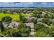 Expansive aerial view of a neighborhood featuring lush greenery, a nearby lake, and well-maintained homes at 7506 Lindenhurst Dr, Orlando, FL 32836