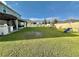 Expansive backyard with lush green grass, a playset, tiki bar, and ample space for outdoor activities at 760 Annabell Ridge Rd, Minneola, FL 34715