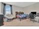 Bright bedroom with a comfortable chair, a twin bed, and a workstation for studying and gaming at 760 Annabell Ridge Rd, Minneola, FL 34715