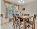 Cozy dining room with a wooden table, comfortable chairs, and natural light from a large window at 760 Annabell Ridge Rd, Minneola, FL 34715