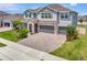 Attractive two-story home featuring a three-car garage, stone detailing, and a spacious brick driveway at 760 Annabell Ridge Rd, Minneola, FL 34715