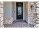 Elegant front entrance with a decorative glass door, stone accents, and a stylish doormat at 760 Annabell Ridge Rd, Minneola, FL 34715