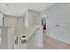 Hallway with neutral carpeting featuring multiple rooms and white bannister at 760 Annabell Ridge Rd, Minneola, FL 34715