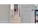 Hallway with tile flooring leading to a bedroom, a storage shelf, and doorway with white trim at 760 Annabell Ridge Rd, Minneola, FL 34715