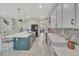 Open-concept kitchen features a large island, white cabinets, stainless steel appliances, and modern backsplash at 760 Annabell Ridge Rd, Minneola, FL 34715