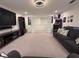 Bright living room featuring neutral carpet, a comfortable sofa, and an entertainment setup, perfect for relaxation at 760 Annabell Ridge Rd, Minneola, FL 34715