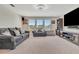 Comfortable living room features plush seating, media center, and natural light from a wall of windows at 760 Annabell Ridge Rd, Minneola, FL 34715