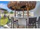Outdoor kitchen with bar, tiki hut, stainless steel grill and comfortable seating at 760 Annabell Ridge Rd, Minneola, FL 34715