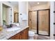 Well-appointed bathroom featuring granite counters, wooden cabinets, and a glass-enclosed shower at 7824 Loxahatchee Ct, Reunion, FL 34747