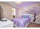 This bedroom features purple accents, plush carpet, and playful wall art at 7824 Loxahatchee Ct, Reunion, FL 34747