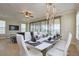 Dining area with stylish table setting for ten, modern lighting, and an open view to living area at 7824 Loxahatchee Ct, Reunion, FL 34747