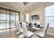 Elegant dining room with a modern chandelier, table setting for ten, and sliding glass doors at 7824 Loxahatchee Ct, Reunion, FL 34747