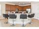 Spacious kitchen features a curved bar, granite counters, stainless steel appliances, and wood cabinetry at 7824 Loxahatchee Ct, Reunion, FL 34747
