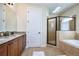 Spacious bathroom with double vanity, soaking tub, and glass-enclosed shower at 7824 Loxahatchee Ct, Reunion, FL 34747