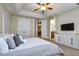 This main bedroom features tray ceilings, ceiling fan, and an ensuite bath at 7824 Loxahatchee Ct, Reunion, FL 34747