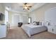 This main bedroom features tray ceilings, a ceiling fan, and carpeted floors at 7824 Loxahatchee Ct, Reunion, FL 34747