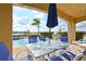 Inviting outdoor dining area overlooks the pool with lush landscaping and a lake view at 7824 Loxahatchee Ct, Reunion, FL 34747