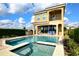 Backyard oasis features a private pool, hot tub, outdoor kitchen, covered patio with furniture, and a privacy hedge at 7824 Loxahatchee Ct, Reunion, FL 34747