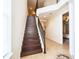 Elegant staircase with wooden steps, decorative iron railing, and neutral walls leading to the upper level at 7824 Loxahatchee Ct, Reunion, FL 34747