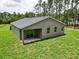 Back exterior featuring a sliding glass door and grassy yard at 8459 Sw 138Th Ter, Dunnellon, FL 34432