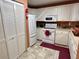 Well-lit kitchen featuring white appliances, ample cabinet space, and modern flooring at 8830 Coral Palms Ct # A, Kissimmee, FL 34747