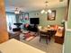 Cozy living room featuring a modern rug, a large screen TV, and dining area at 8830 Coral Palms Ct # A, Kissimmee, FL 34747