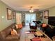 Comfortable living room with carpeted floors, stylish rug, and outdoor access at 8830 Coral Palms Ct # A, Kissimmee, FL 34747