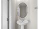 This bathroom features a pedestal sink, an oval mirror and bright, clean design at 926 Paradise Dr, Davenport, FL 33897