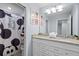 Bathroom featuring double sinks, granite countertop, Mickey Mouse shower curtain and decorative art at 926 Paradise Dr, Davenport, FL 33897