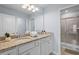 Well-lit bathroom featuring double vanity with granite countertop and tiled shower at 926 Paradise Dr, Davenport, FL 33897