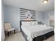 Inviting bedroom with a king-size bed, decorative wall accents, and two windows at 926 Paradise Dr, Davenport, FL 33897