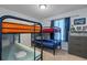 Bedroom featuring a fun bunkbed, a window with blue curtains and a dresser at 926 Paradise Dr, Davenport, FL 33897
