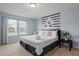 Inviting bedroom with a king-size bed, decorative wall accents, and two windows at 926 Paradise Dr, Davenport, FL 33897