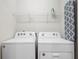 Laundry room with modern washer, dryer, storage shelf and ironing board at 926 Paradise Dr, Davenport, FL 33897