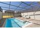 This is an inviting screened-in pool area featuring lounge chairs and a grill at 926 Paradise Dr, Davenport, FL 33897