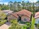 Beautiful aerial view of a home with a tile roof, attached garage, and lush green surroundings at 9346 San Jose Blvd, Howey In The Hills, FL 34737