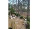 A relaxing backyard featuring Adirondack chairs, a stone patio, and wooded views at 9346 San Jose Blvd, Howey In The Hills, FL 34737
