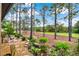 Beautiful backyard with lush landscaping, mature trees, and a stone path at 9346 San Jose Blvd, Howey In The Hills, FL 34737