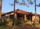 Back exterior with screened in patio area surrounded by lush landscaping at 9346 San Jose Blvd, Howey In The Hills, FL 34737