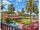 Stunning exterior view of the clubhouse with a fountain, tropical plants, and a golf course in the background at 9346 San Jose Blvd, Howey In The Hills, FL 34737