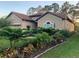 Inviting home featuring a well-kept lawn and diverse landscaping with vibrant plants and trees at 9346 San Jose Blvd, Howey In The Hills, FL 34737