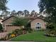 Charming home featuring a beautifully landscaped front yard with vibrant flowers and lush green grass at 9346 San Jose Blvd, Howey In The Hills, FL 34737