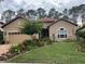 Charming home featuring a well-manicured lawn, lush landscaping, and a welcoming front facade at 9346 San Jose Blvd, Howey In The Hills, FL 34737