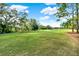 Scenic golf course view with lush green grass, mature trees, and a clear blue sky at 9346 San Jose Blvd, Howey In The Hills, FL 34737