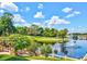 Beautiful golf course view with a pond and fountain, lush trees and flowers on a sunny day with blue skies at 9346 San Jose Blvd, Howey In The Hills, FL 34737
