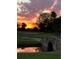 Scenic view of a golf course at sunset, with a bridge over a pond reflecting the colorful sky at 9346 San Jose Blvd, Howey In The Hills, FL 34737