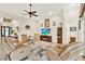 Spacious living room with plush armchairs, ceiling fan, decorative accents, and a television at 9346 San Jose Blvd, Howey In The Hills, FL 34737